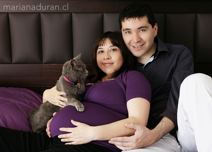 Futuros padres con su gata sobre la pancita