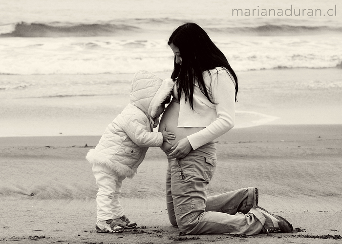 Niña dando un beso a la guatita de su mamá en Playa Amarilla, Concón, Chile