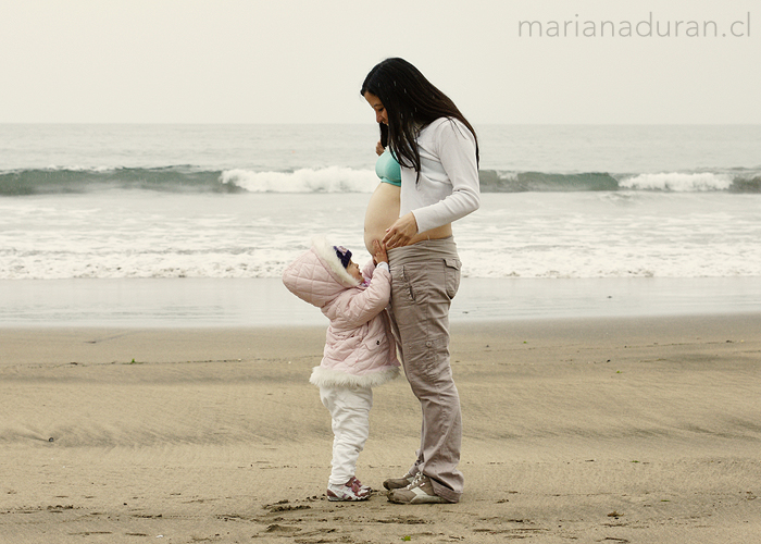 Madre embarazada e hija en la playa