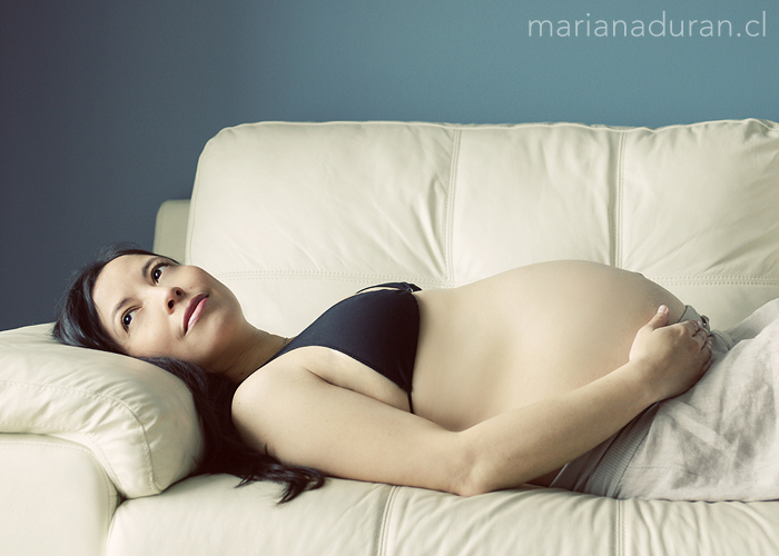 Mujer embarazada recostada en un sofá
