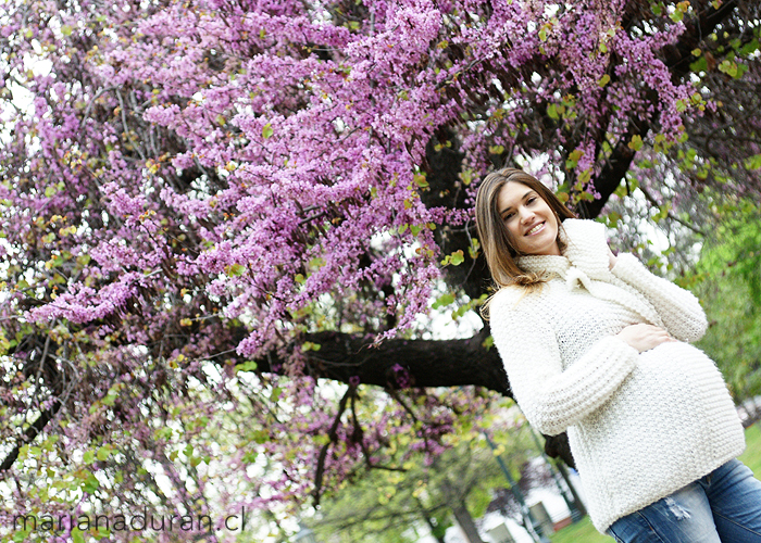Madre embarazada con chaleco blanco y flores lilas