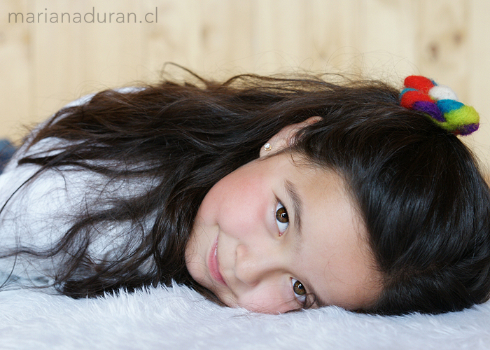 Rostro de niña recostada sobre un felpudo blanco