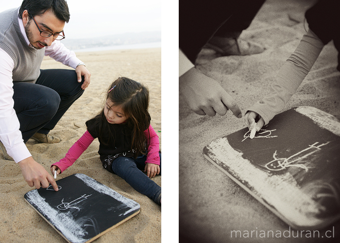 papá e hija dibujando en la arena